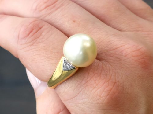 fig 3. A vintage 18ct yellow gold ring featuring a central round cream cultured pearl flanked by two triangular diamonds.