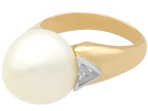 fig 5. A vintage 18ct yellow gold ring featuring a central round cream cultured pearl flanked by two triangular diamonds.
