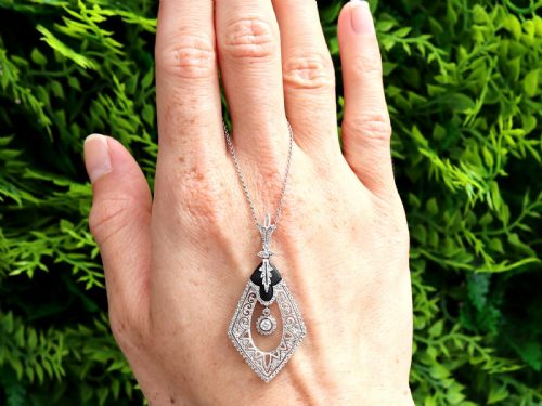 fig 1. A diamond-shaped Art Deco platinum filigree pendant set with carved black onyx and a central suspended diamond drop.