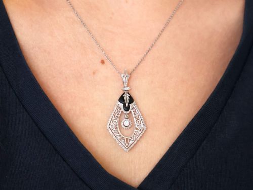fig 2. A diamond-shaped Art Deco platinum filigree pendant set with carved black onyx and a central suspended diamond drop.
