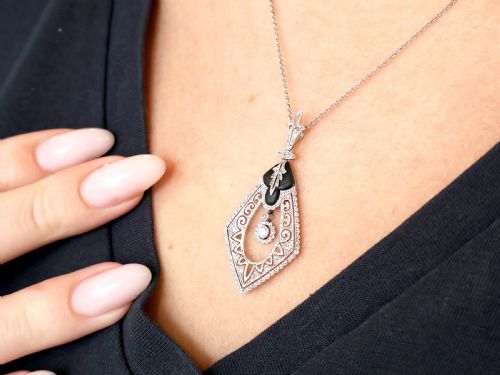 fig 3. A diamond-shaped Art Deco platinum filigree pendant set with carved black onyx and a central suspended diamond drop.