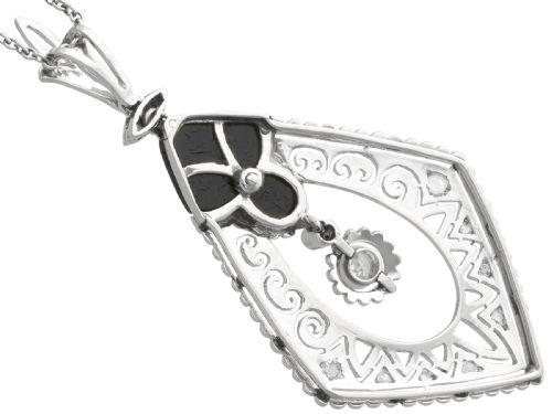 fig 6. A diamond-shaped Art Deco platinum filigree pendant set with carved black onyx and a central suspended diamond drop.