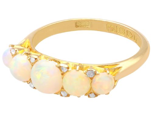 fig 6. An Edwardian 18ct yellow gold five stone ring featuring graduated cabochon white opals with small diamond accents and full interior British hallmarks.
