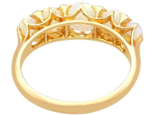 fig 7. An Edwardian 18ct yellow gold five stone ring featuring graduated cabochon white opals with small diamond accents and full interior British hallmarks.