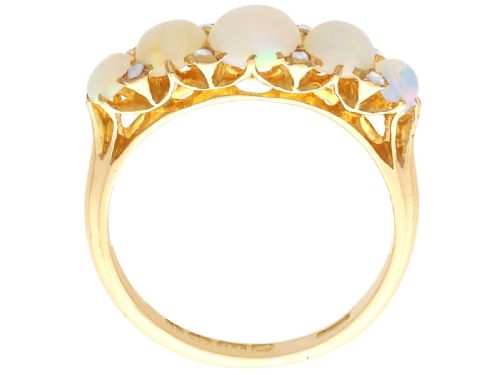 fig 8. An Edwardian 18ct yellow gold five stone ring featuring graduated cabochon white opals with small diamond accents and full interior British hallmarks.