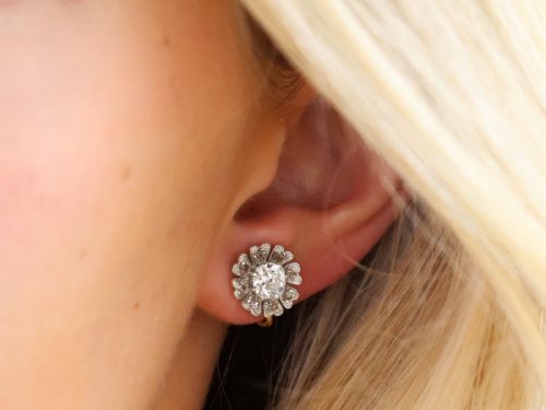 fig 2. Pair of late nineteenth-century floral cluster earrings featuring central cushion-cut diamonds surrounded by silver-set diamond petals with yellow gold fittings.