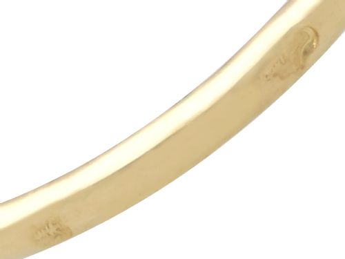fig 8. An 18ct yellow gold ring featuring a central emerald-cut blue sapphire framed by a geometric double halo of round diamonds with millegrain edging.