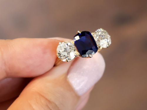 fig 3. An 18ct yellow gold Victorian trilogy ring set with a central cushion cut blue sapphire flanked by two round old cut diamonds.