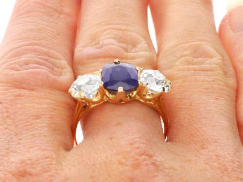 fig 9. An 18ct yellow gold Victorian trilogy ring set with a central cushion cut blue sapphire flanked by two round old cut diamonds.