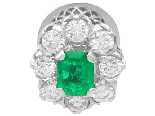 fig 4. A pair of 18ct white gold cluster earrings featuring central emerald-cut green emeralds surrounded by a halo of round brilliant diamonds.