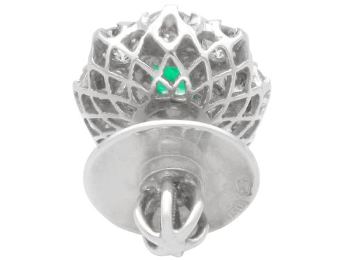 fig 5. A pair of 18ct white gold cluster earrings featuring central emerald-cut green emeralds surrounded by a halo of round brilliant diamonds.