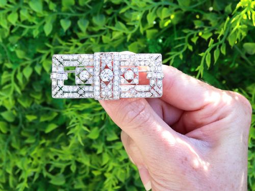 fig 1. A rectangular Art Deco platinum brooch featuring intricate geometric openwork millegrain setting filled with round diamonds surrounding a central bezel-set diamond.