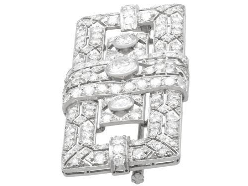 fig 4. A rectangular Art Deco platinum brooch featuring intricate geometric openwork millegrain setting filled with round diamonds surrounding a central bezel-set diamond.
