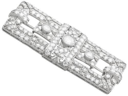 fig 5. A rectangular Art Deco platinum brooch featuring intricate geometric openwork millegrain setting filled with round diamonds surrounding a central bezel-set diamond.