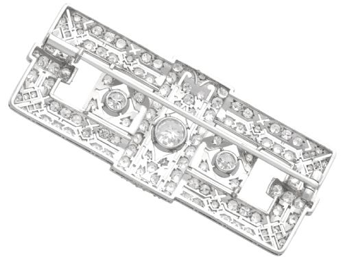 fig 6. A rectangular Art Deco platinum brooch featuring intricate geometric openwork millegrain setting filled with round diamonds surrounding a central bezel-set diamond.