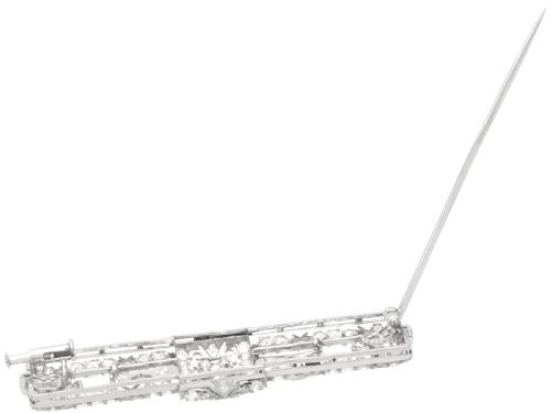 fig 7. A rectangular Art Deco platinum brooch featuring intricate geometric openwork millegrain setting filled with round diamonds surrounding a central bezel-set diamond.