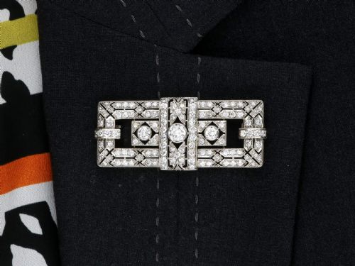 fig 10. A rectangular Art Deco platinum brooch featuring intricate geometric openwork millegrain setting filled with round diamonds surrounding a central bezel-set diamond.