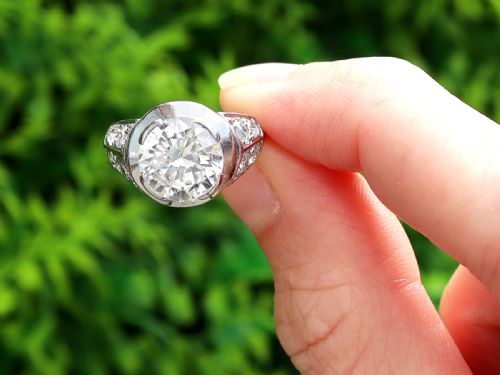 fig 1. An Art Deco platinum ring featuring a central round diamond set in a smooth bezel with accent diamonds on the shoulders.