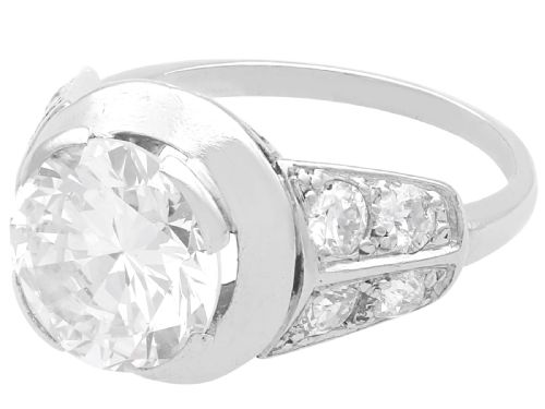 fig 2. An Art Deco platinum ring featuring a central round diamond set in a smooth bezel with accent diamonds on the shoulders.