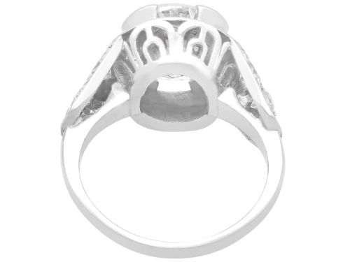 fig 3. An Art Deco platinum ring featuring a central round diamond set in a smooth bezel with accent diamonds on the shoulders.