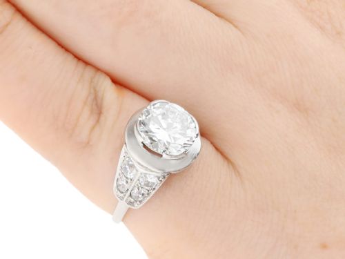 fig 7. An Art Deco platinum ring featuring a central round diamond set in a smooth bezel with accent diamonds on the shoulders.