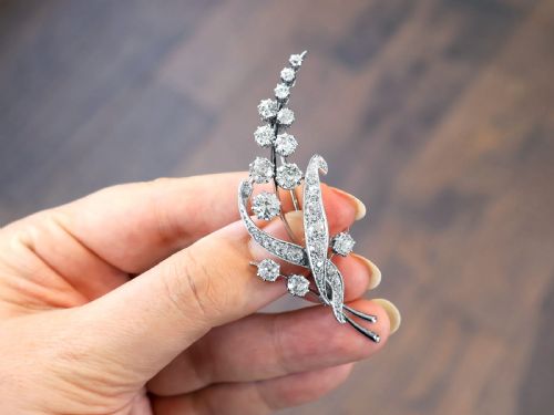 fig 2. An antique 18ct white gold floral spray brooch set with round diamonds in a stylized leaf sprig design.