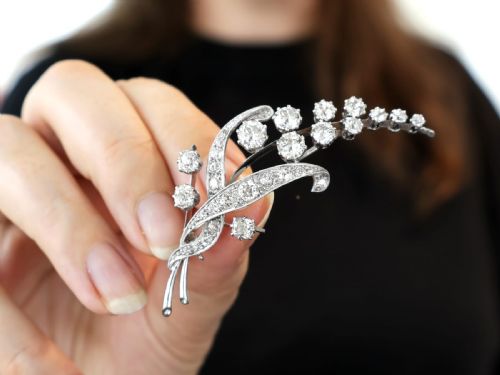 fig 3. An antique 18ct white gold floral spray brooch set with round diamonds in a stylized leaf sprig design.