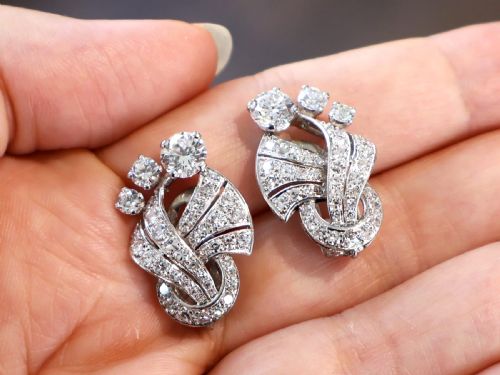 fig 2. A pair of platinum earrings crafted in a sweeping fan and scroll design, fully set with brilliant-cut diamonds.