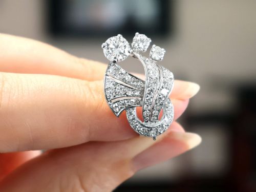 fig 3. A pair of platinum earrings crafted in a sweeping fan and scroll design, fully set with brilliant-cut diamonds.
