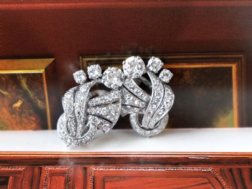 fig 4. A pair of platinum earrings crafted in a sweeping fan and scroll design, fully set with brilliant-cut diamonds.