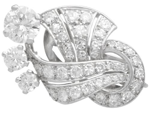 fig 6. A pair of platinum earrings crafted in a sweeping fan and scroll design, fully set with brilliant-cut diamonds.
