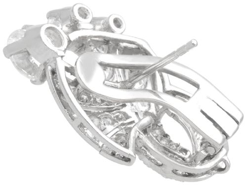 fig 7. A pair of platinum earrings crafted in a sweeping fan and scroll design, fully set with brilliant-cut diamonds.