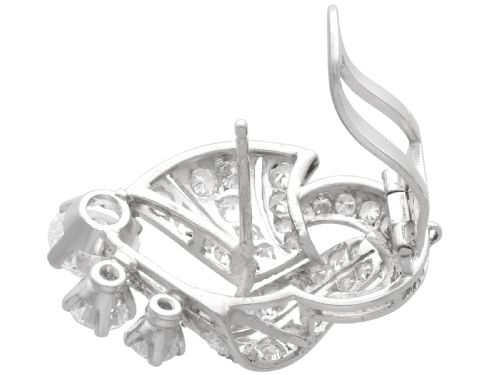 fig 8. A pair of platinum earrings crafted in a sweeping fan and scroll design, fully set with brilliant-cut diamonds.