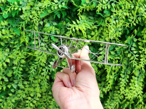 fig 1. A sterling silver scale model of a George V era Sopwith biplane featuring twin wings, a propeller, two wheels, and wire rigging.