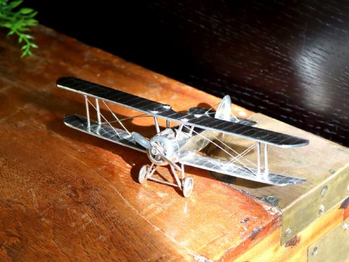 fig 2. A sterling silver scale model of a George V era Sopwith biplane featuring twin wings, a propeller, two wheels, and wire rigging.