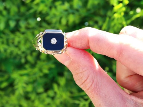 fig 1. A 14ct yellow gold signet ring set with an octagonal black onyx plaque featuring a central round diamond bezel setting.