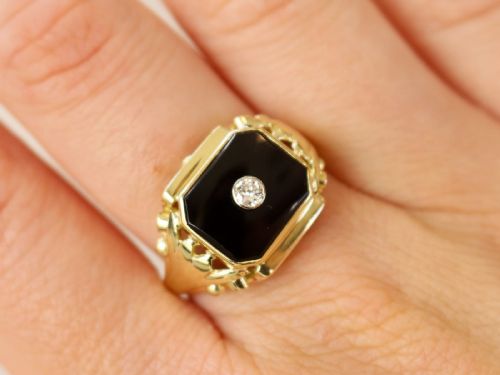 fig 2. A 14ct yellow gold signet ring set with an octagonal black onyx plaque featuring a central round diamond bezel setting.