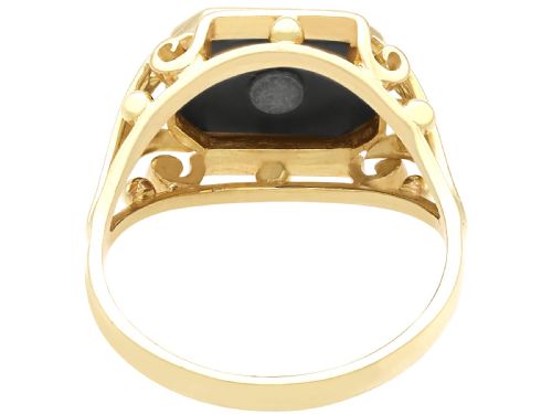 fig 4. A 14ct yellow gold signet ring set with an octagonal black onyx plaque featuring a central round diamond bezel setting.
