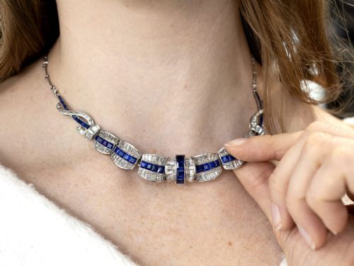 fig 2. An Art Deco platinum collar necklace set with central square-cut blue sapphires bordered by baguette and round diamonds.