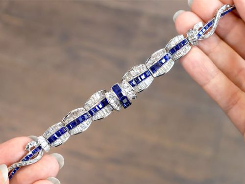 fig 4. An Art Deco platinum collar necklace set with central square-cut blue sapphires bordered by baguette and round diamonds.