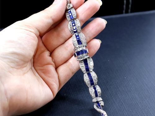 fig 5. An Art Deco platinum collar necklace set with central square-cut blue sapphires bordered by baguette and round diamonds.