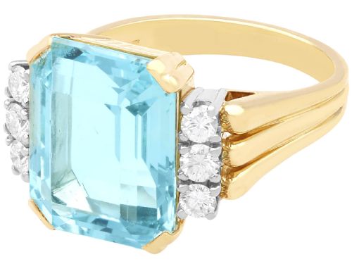 fig 4. A 14ct yellow gold dress ring featuring a large emerald-cut light blue aquamarine central gemstone flanked by six round diamonds.
