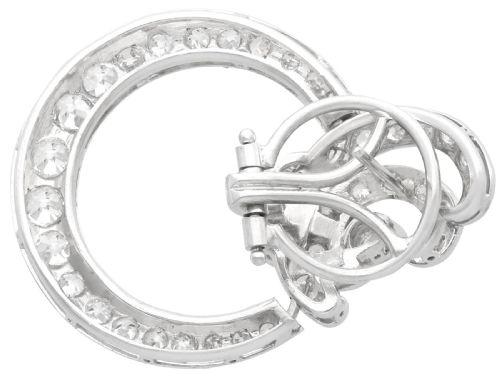 fig 2. Pair of platinum clip-on earrings featuring circular diamond-set lower hoops suspended from geometric diamond scroll tops.
