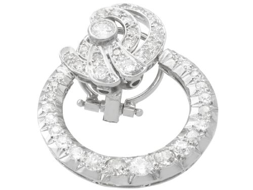 fig 3. Pair of platinum clip-on earrings featuring circular diamond-set lower hoops suspended from geometric diamond scroll tops.