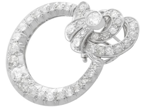 fig 5. Pair of platinum clip-on earrings featuring circular diamond-set lower hoops suspended from geometric diamond scroll tops.