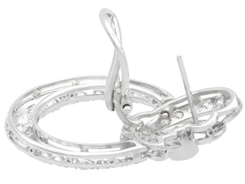 fig 6. Pair of platinum clip-on earrings featuring circular diamond-set lower hoops suspended from geometric diamond scroll tops.