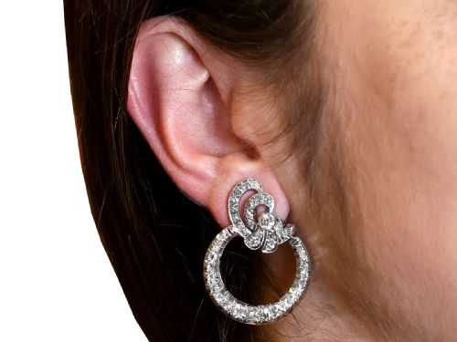fig 7. Pair of platinum clip-on earrings featuring circular diamond-set lower hoops suspended from geometric diamond scroll tops.