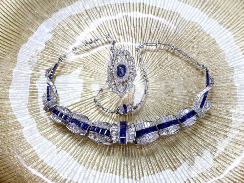 fig 7. An Art Deco platinum collar necklace set with central square-cut blue sapphires bordered by baguette and round diamonds.