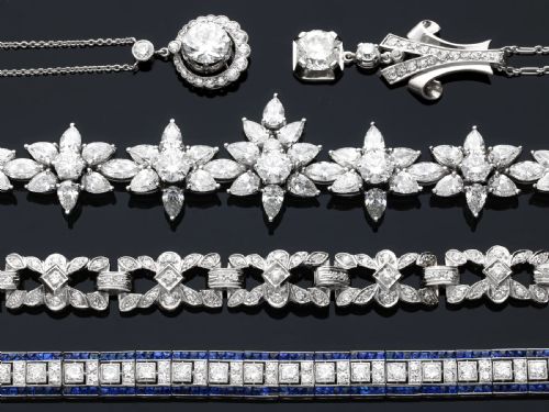 fig 5. An antique platinum halo pendant featuring a central round diamond surrounded by a scalloped border of smaller diamonds on a fine chain.