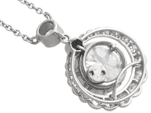 fig 8. An antique platinum halo pendant featuring a central round diamond surrounded by a scalloped border of smaller diamonds on a fine chain.